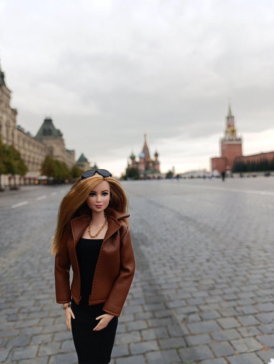 Позади Трис мы видим Главный универсальный магазин(ГУМ) Храм Василия Блаженного и Спасскую башню Московского Кремля