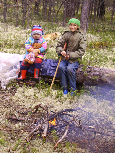 Отдыхают внуки у костерка, ждут чай. Собака лежит, отдыхает.
