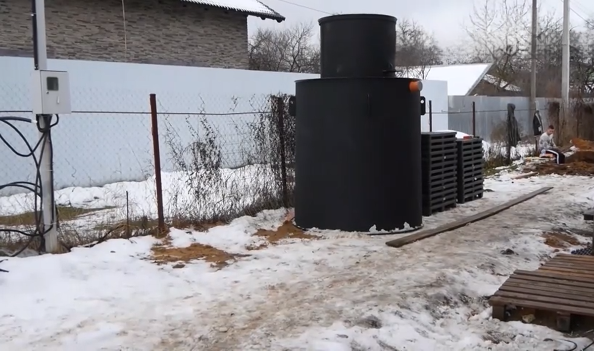 Пластиковый септик и две стопки поддонов. Иллюстрация Водоуслуги ру