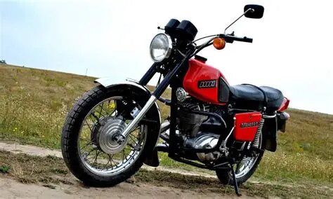 «Иж Планета 5» — Одинокий странник

Планета 5 – это паровоз, имеет приличный крутящий момент, но при воздействии на ручку газа реагирует очень вяло. Передачи переключаются с перегазовкой. Зато тяга на голову выше за счет своего крутящего момента он как трактор. Ещё одно отличие это отсутствие проблем с зажиганием. Ремонтировать его ещё легче и дешеве. Расход топлива считается маленьким.

Узнаваем по одиночному пассажирскому седлу и шильдику "Планета" на баке.

Концепция: Дорожный мотоцикл-одиночка (сингл). «Планета» создавалась для быстрой и комфортной езды по шоссе, в основном, для одного человека.

Главное визуальное отличие: седло и задняя часть

· Седло: Длинное и узкое, рассчитанное преимущественно на одного водителя. Пассажирское место минимально и некомфортно для долгих поездок.
· Задняя подвеска: Одна пружинная стойка (моноамортизатор) по центру. Это придает задней части лаконичный и стремительный вид.
· Задний щиток: Узкий, интегрированный с крылом.

Плюсы «Планеты 5»:

· Лучшая разгонная динамика: Меньший вес (примерно на 10-15 кг) и облегченная задняя часть делают его чуть более резвым на разгоне.
· Жёстче и стабильнее на скорости: Одинарная задняя подвеска обеспечивает лучшую курсовую устойчивость на прямой, особенно на высоких скоростях.
· Классический стиль: Многие ценители находят его дизайн более гармоничным и «брутальным».

Минусы:

· Непрактичность для пассажира: Ехать вдвоем — сущее наказание.
· Жёстковатая подвеска: При езде по неровной дороге комфорт страдает.