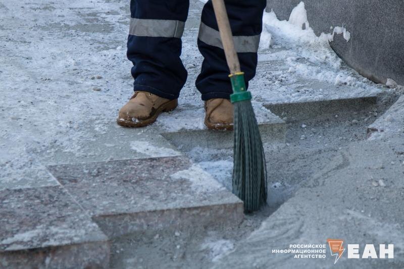    Рабочий подметает улицу