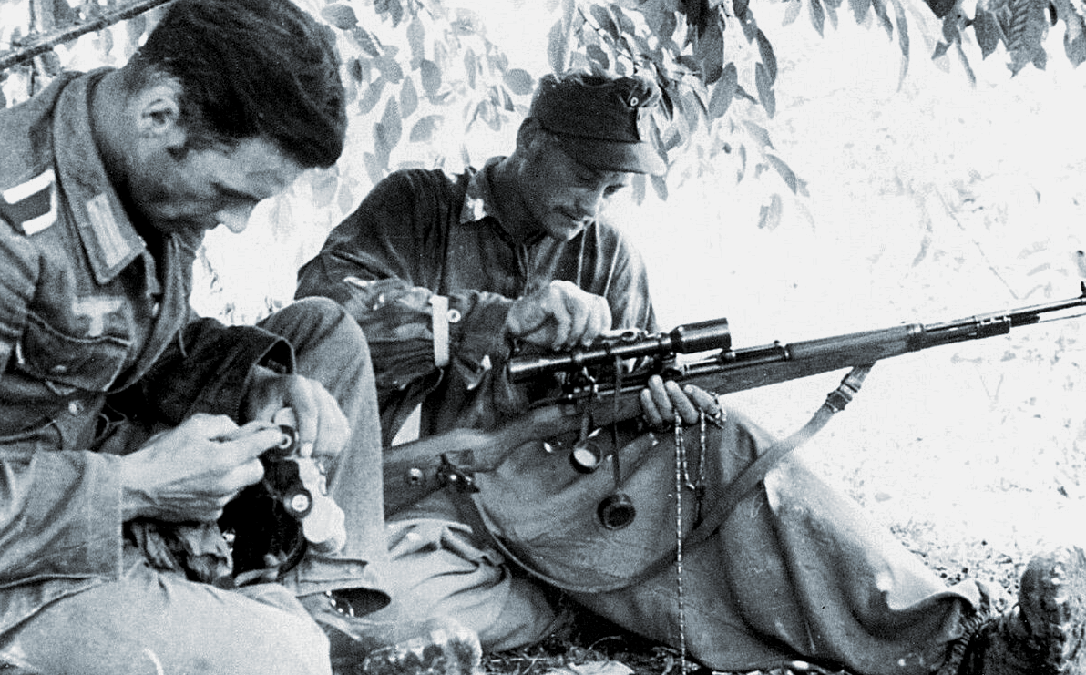 Стрелки вермахта чистят оружие и снаряжение во время перерыва в бою.