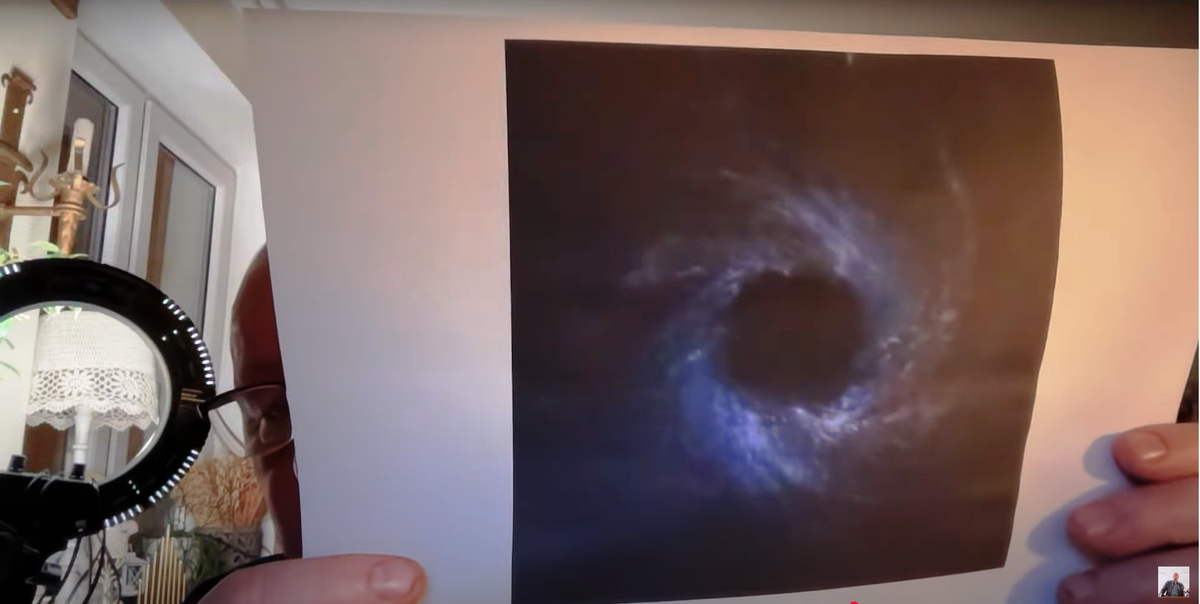 Момент онлайн-трансляции от 03 января 2025 года: экстрасенс Кшиштоф Яцковский демонстрирует иллюстрацию с изображением т.н. черной дыры, по которой собирается сделать визию. 