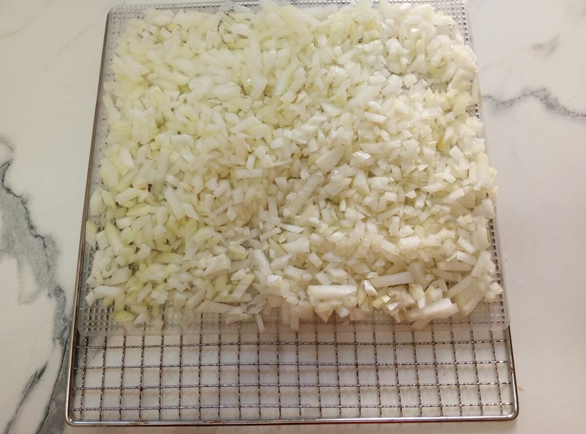 Выкладывать лук следует слоем в 1,5-2 см, он хорошо просушится при выкладывании на сетку