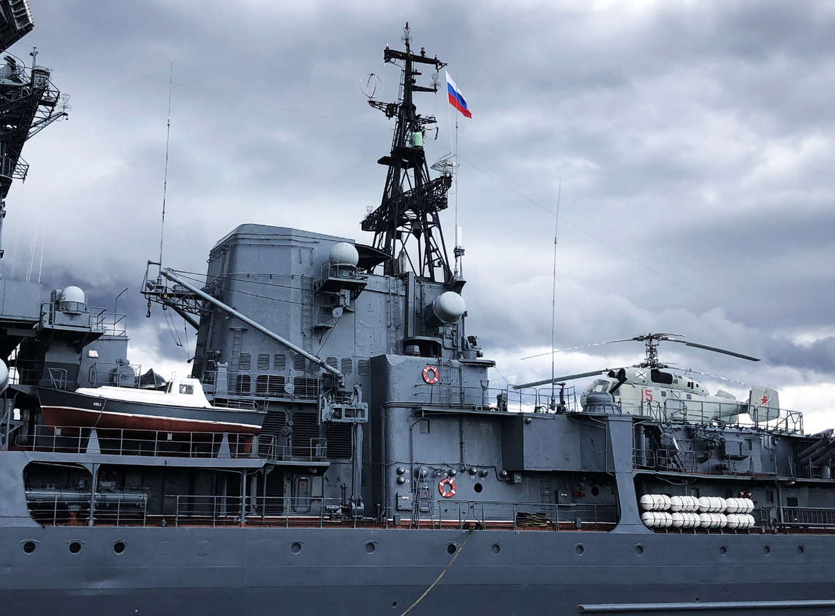 Фрагмент кормового блока надстроек с дымовой трубой и грот-мачтой. На ВПП сдвижного ангара- вертолет Ка-27.