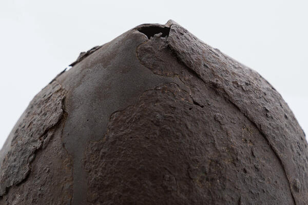 Шлем неполный по форме, утрачены большие фрагменты поверхности в нижней, средней и верхней части, множественные сквозные отверстия, трещины, деформация, поверхность повреждена коррозией, обработана и законсервирована. Восстановлена полная форма.