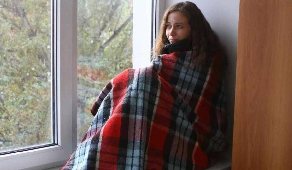     Девушка сидит на подоконнике в одеяле. Источник: chel.kp.ru Автор фото: Роман Игнатьев