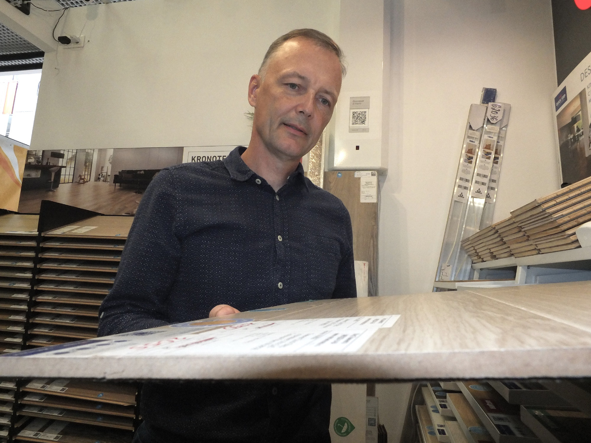 Алексей Анисимов, директор компании "Мир ламината". На срезе образца видна форма замка Uniclic