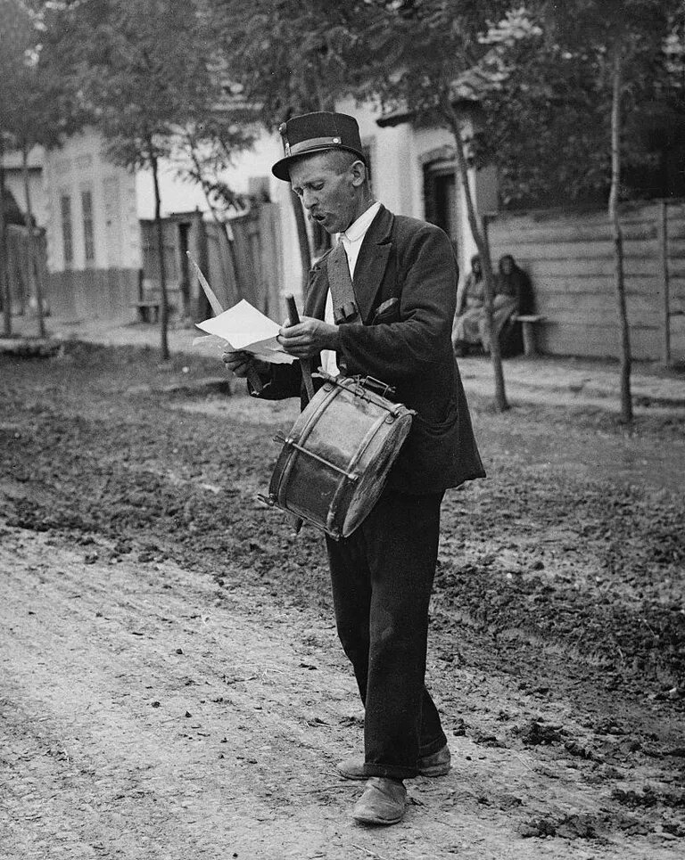 Черно-белая фотография городского глашатая с барабаном, объявляющего новости в Надьреве в 1929 году. Фото: Getty Images