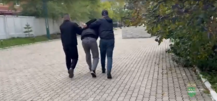 Одного из задержанных ведут в отделение полиции / Скриншот кадра видео УМВД России по Амурской области