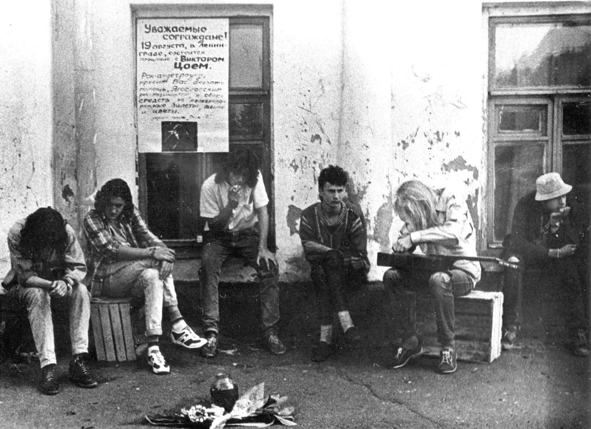 Фото и комментарии Захара Потёмкина. Место сборов на поездку, самый центр Ярославля. Слева направо - не помню кто, лица не видно, Туча (Лёня Жиров) басист, Аркадий Громов (басист/гитарист), Фил Золотарёв (группа «Никотин»), Гай (гитара «Никотин»), кто-то, не помню. Август 1990г.