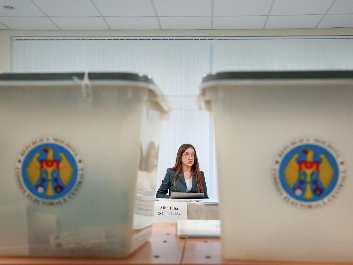    Сотрудник избирательной комиссии на избирательном участке во время парламентских выборов в Кишинёве, Молдова© AP Photo / Vadim Ghirda