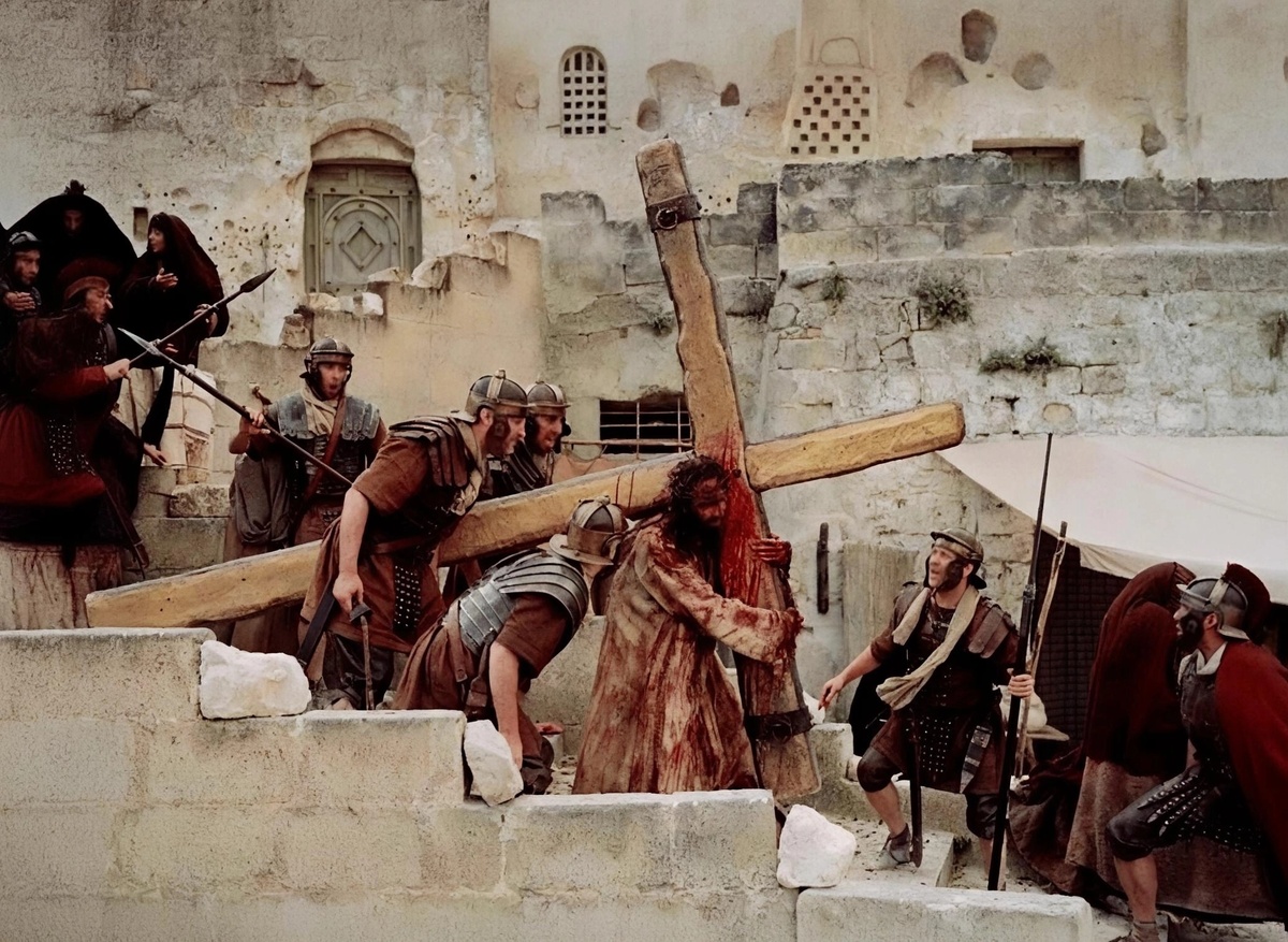 Иисус несёт крест на Голгофу. Кадр из фильма «Страсти Христовы» (2006 г., режиссёр Мэл Гибсон).