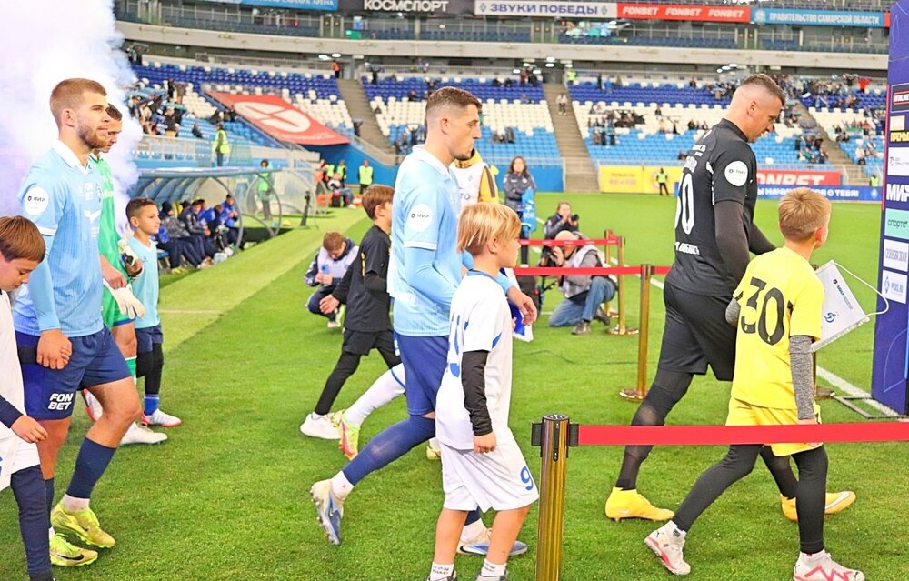 Футболисты в сопровождении детей выходят на поле.