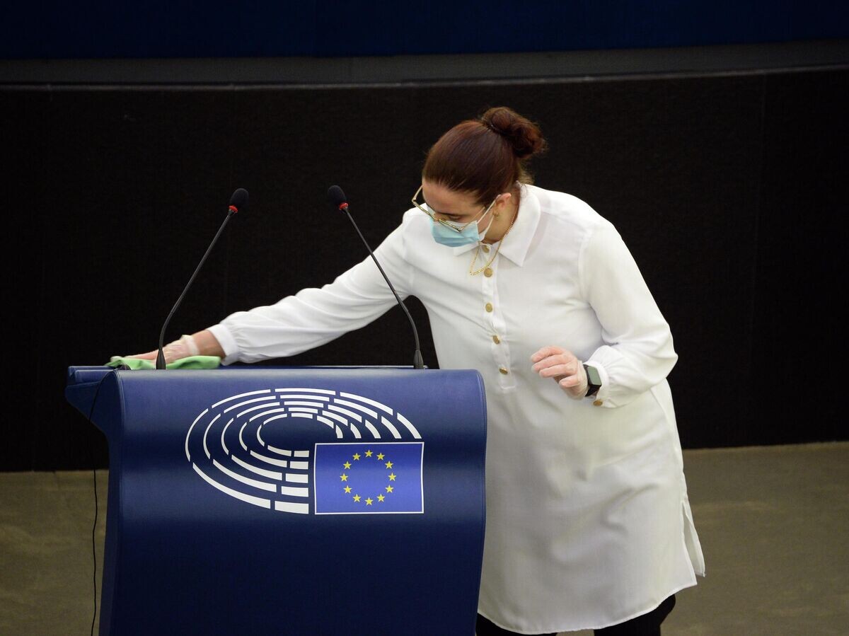 Сотрудница дезинфицирует трибуну после выступления депутатов на пленарной сессии Европейского парламента в Страсбурге© РИА Новости / Алексей Витвицкий