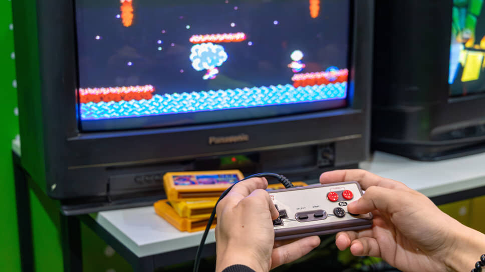 Джойстик от игровой приставки Dendy в руках посетителя форума «Цифроземье» в Воронеже.📷Фото: Егор Снетков / Коммерсантъ