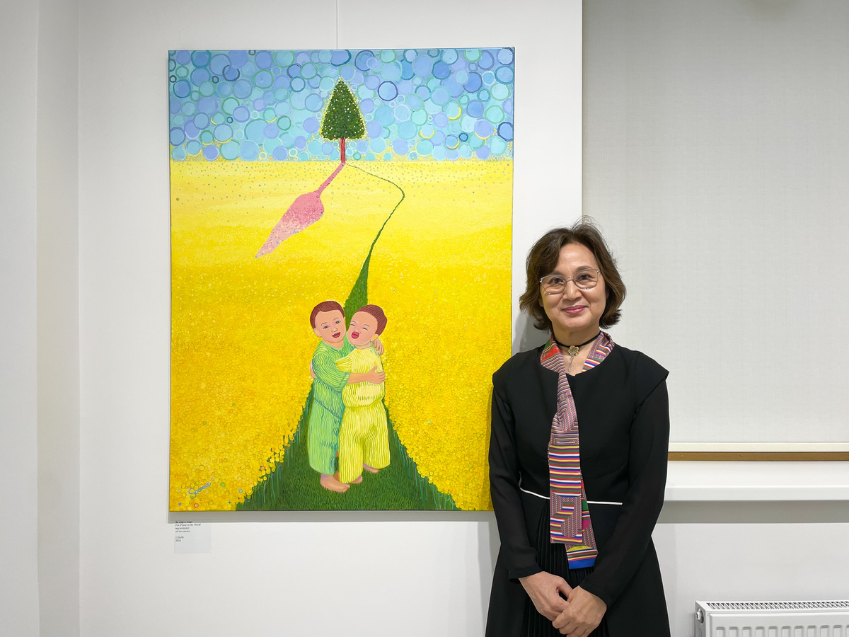 Художница рядом со своей картиной "За мир в мире" (2024).