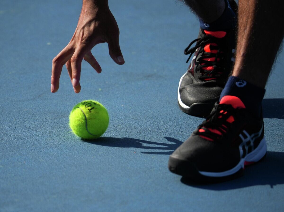    Волонтер подает теннисный мяч на Олимпиаде в Токио© РИА Новости / Владимир Песня