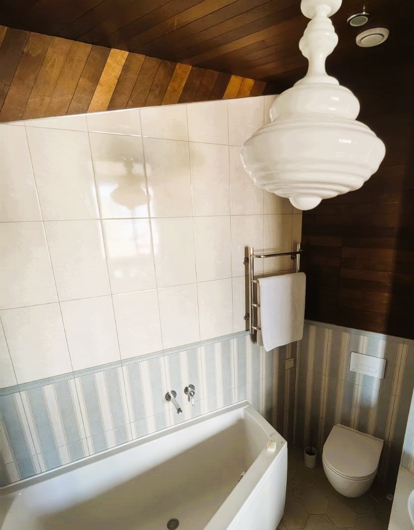 "ломанный" дощатый потолок и шикарный светильник