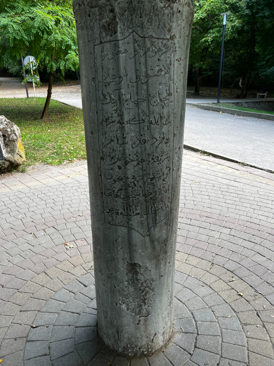 Простой камень-столб с затейливой арабской вязью, выбитой на поверхности.