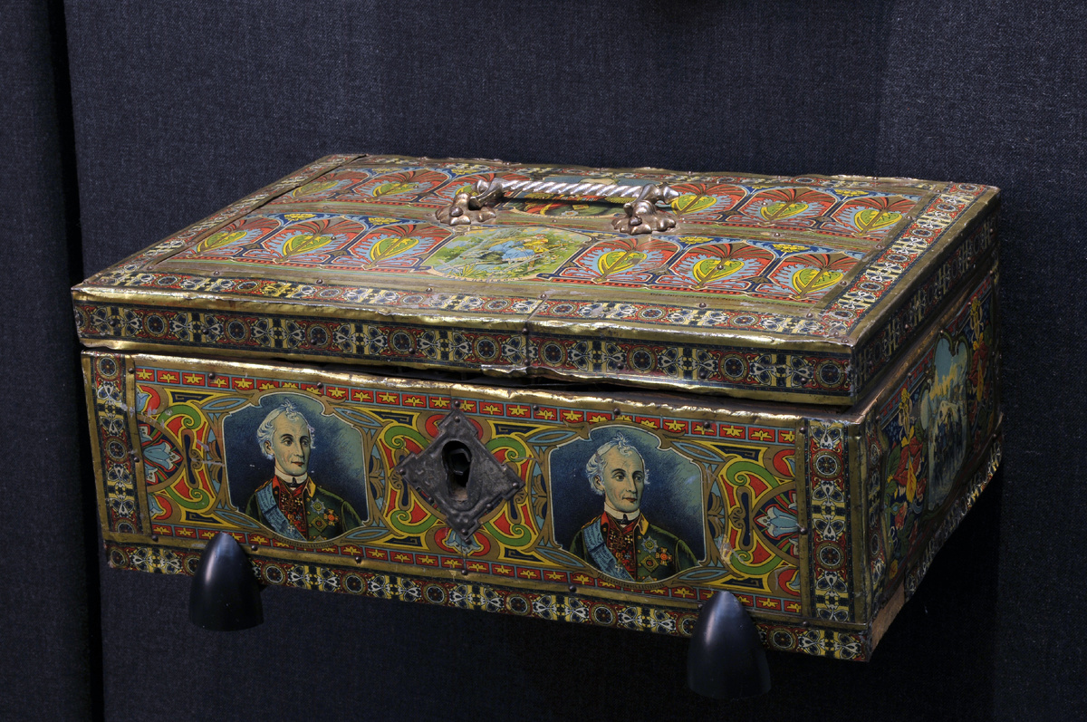Сундук-шкатулка. Бытовала в семье жительницы Нижнего Тагила Е.Н. Телепневой,  работавшей бухгалтером на Лебяжинском и Высокогорском рудниках.  Дерево, жесть, хромолитография. Начало ХХ века