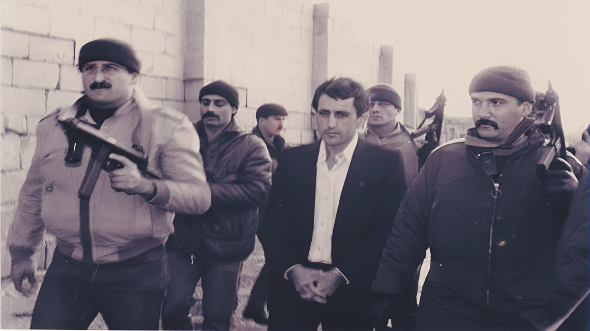 Омар Резак в окружении полицейских