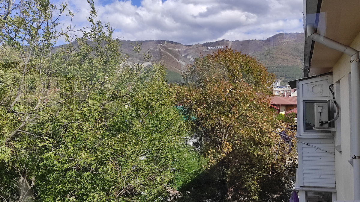 С балкона видна гора, крест и надпись Геленджик. А двор очень зеленый - каштаны и орехи выше крыши! Фото: Кирилл Полиенко/Polienko: путешествуем вдвоём