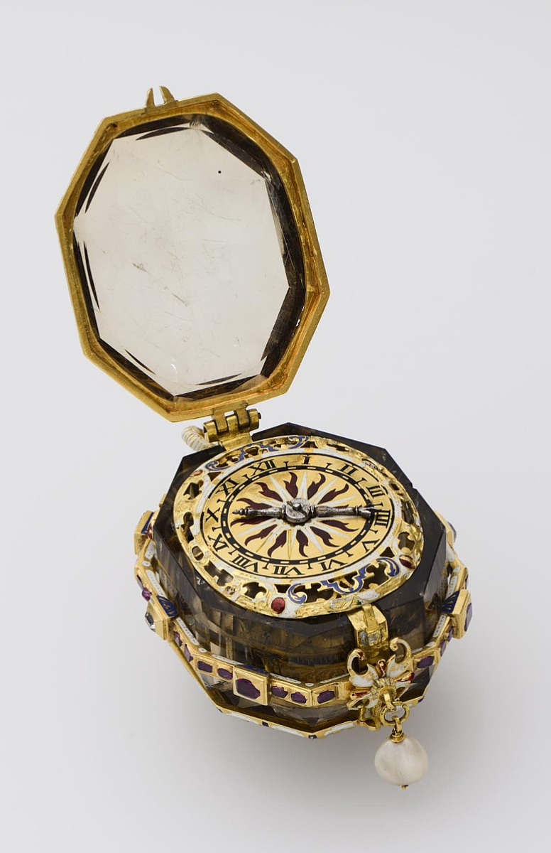 Часы карманные с боем.
Аугсбург, около 1600 г.
Мастер Якоб ван Кресс (Jakob van Kress).
Монограмма часового мастера  «I.V.K» на платине. Клейм нет.
Золото, бриллианты, рубины, дымчатый топаз, жемчуг.
Резьба, гравировка, эмаль.
Размеры: 8,0 х 5,0 см