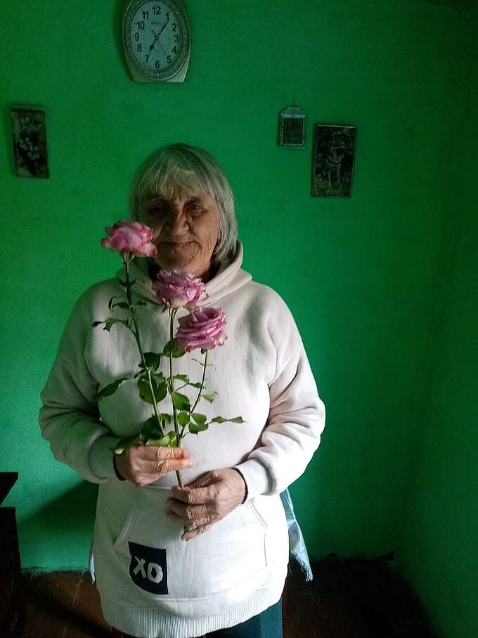 Пожилая женщина с подаренными ей розами