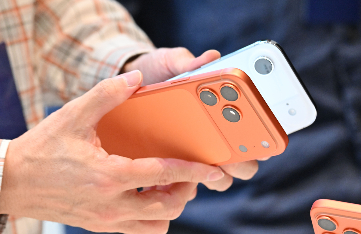 Покупатель держит оранжевый iPhone 17 Pro в Apple Store на Мёндоне в центре Сеула. (Лим Се Джун / The Korea Herald)