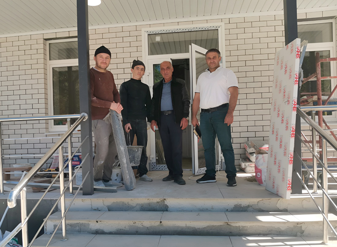 Глава администрации п. Домбай Алимурат Байчоров (справа) со строителями амбулатории. Фото автора.