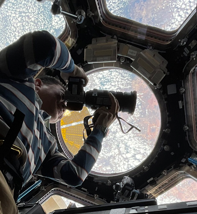 Кимия Юи ведет фотосъемку из ОМ Cupola. Фото: JAXA