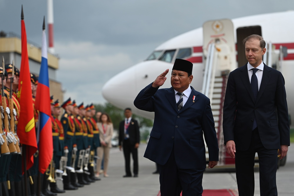 Президент Индонезии Прабово Субианто (слева) и первый заместитель председателя правительства РФ Денис Мантуров (справа) идут мимо роты почетного караула в аэропорту Пулково, Санкт-Петербург, 18 июня 2025 года.