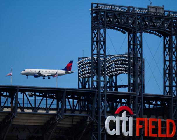 Самолет компании «Delta» пролетает над Сити-Филд, совершая последний заход на посадку в аэропорт Ла-Гуардиа в Нью-Йорке.