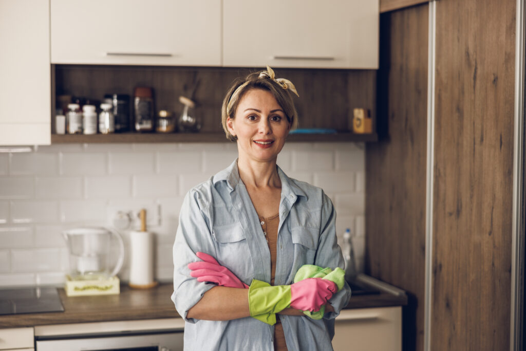    Portrait of a smiling mature woman with wearing protective glove while keeping her house clean. Looking at camera. admin