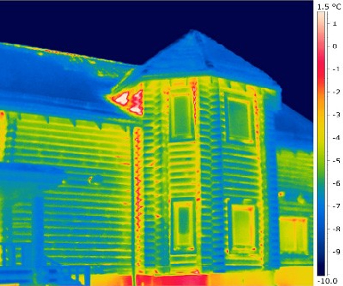 Сруб деревянного дома зимой на экране тепловизора