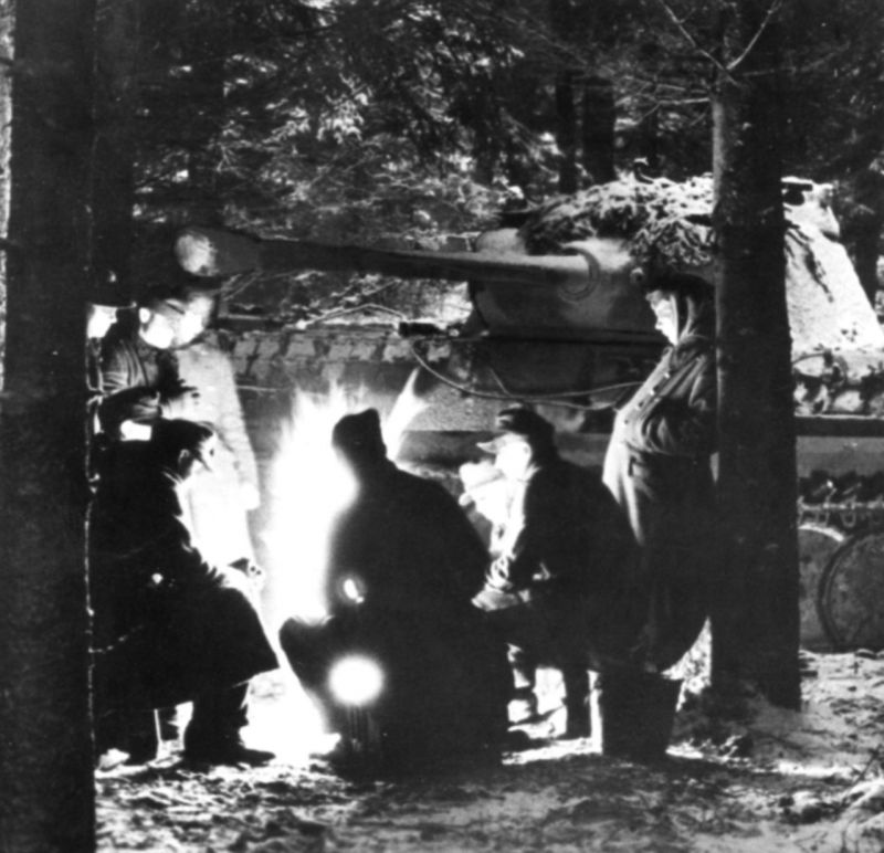 Танкисты вермахта у костра в рождественскую ночь в ходе боев в Арденнах. На заднем плане танк Pz.Kpfw. V Panther