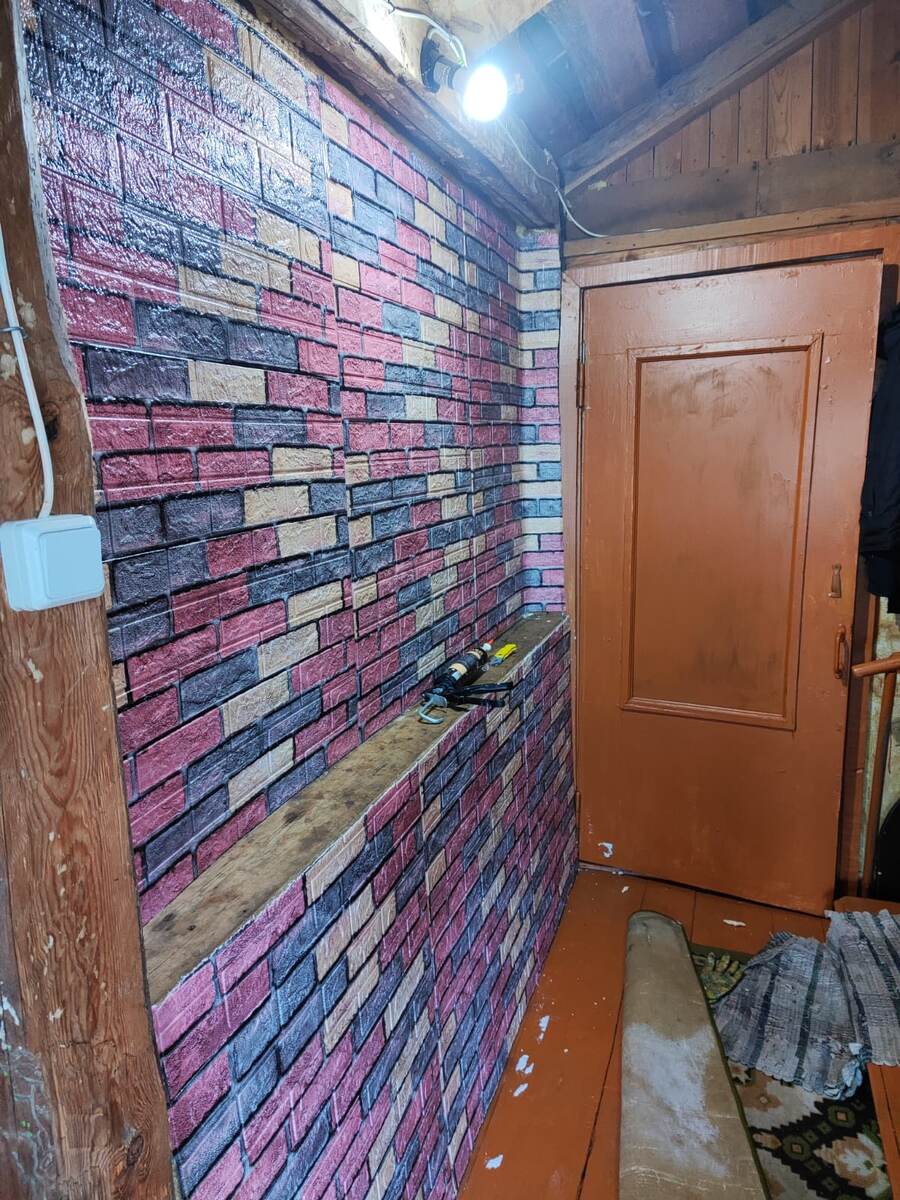 стена в коридоре поклеянная панелями под кирпич.