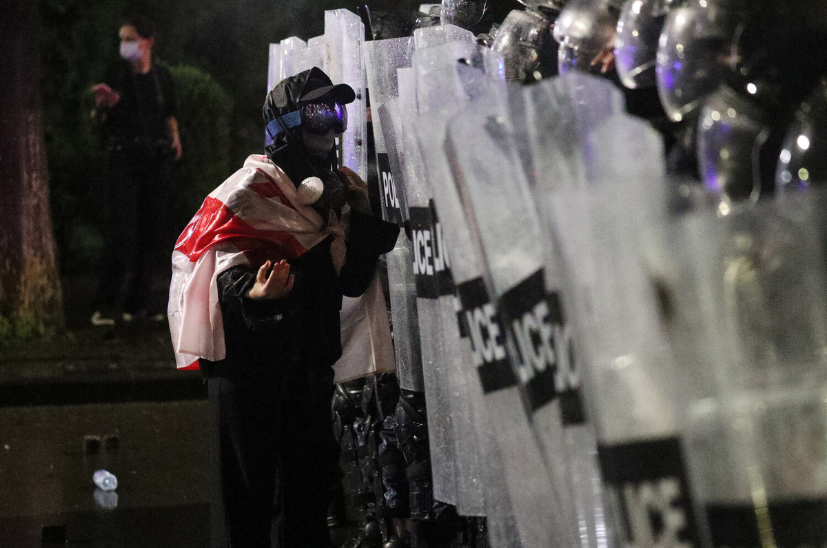 Участник акции протеста разговаривает с полицейскими во время митинга оппозиции после муниципальных выборов в Тбилиси, 4 октября 2025 года ©Irakli Gedenidze/Reuters  📷