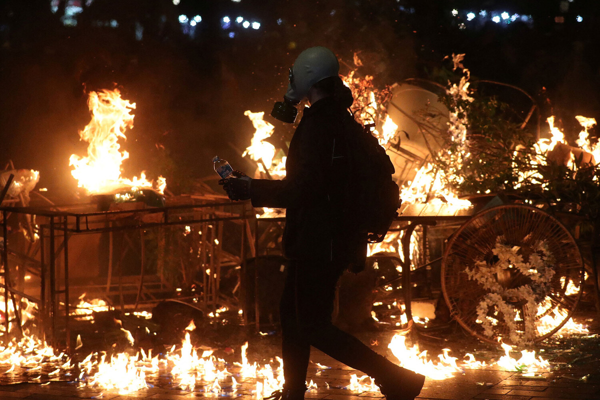 Протестующий на фоне горящей баррикады во время митинга оппозиции в Тбилиси, 4 октября 2025 года ©Irakli Gedenidze/Reuters  📷