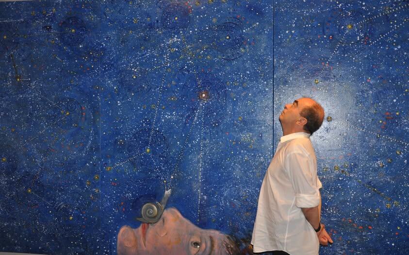 Фото  Санти А. Сагредо (из открытых источников). Художник  Эль Хортелано (El Hortelano) на своей выставке  «Включи свет» в комнате Робайера рядом со своей картиной «Южный крест».  (Триптих) Холст масло. 200 х 400 см. 2014. 