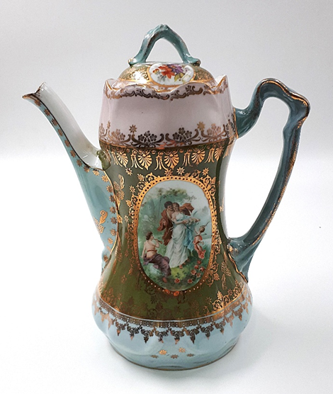 Кофейник из кофейного сервиза. МИТ КП 723/2.
Владимирская губерния, Дулёвский фарфоровый завод «Товарищество производства фарфоровых, фаянсовых и майоликовых изделий М.С. Кузнецова», 1910-е гг. 
Фарфор, деколь, позолота. Высота - 22,7 см. Поздний венский стиль (в манере Ангелики Кауфман).
