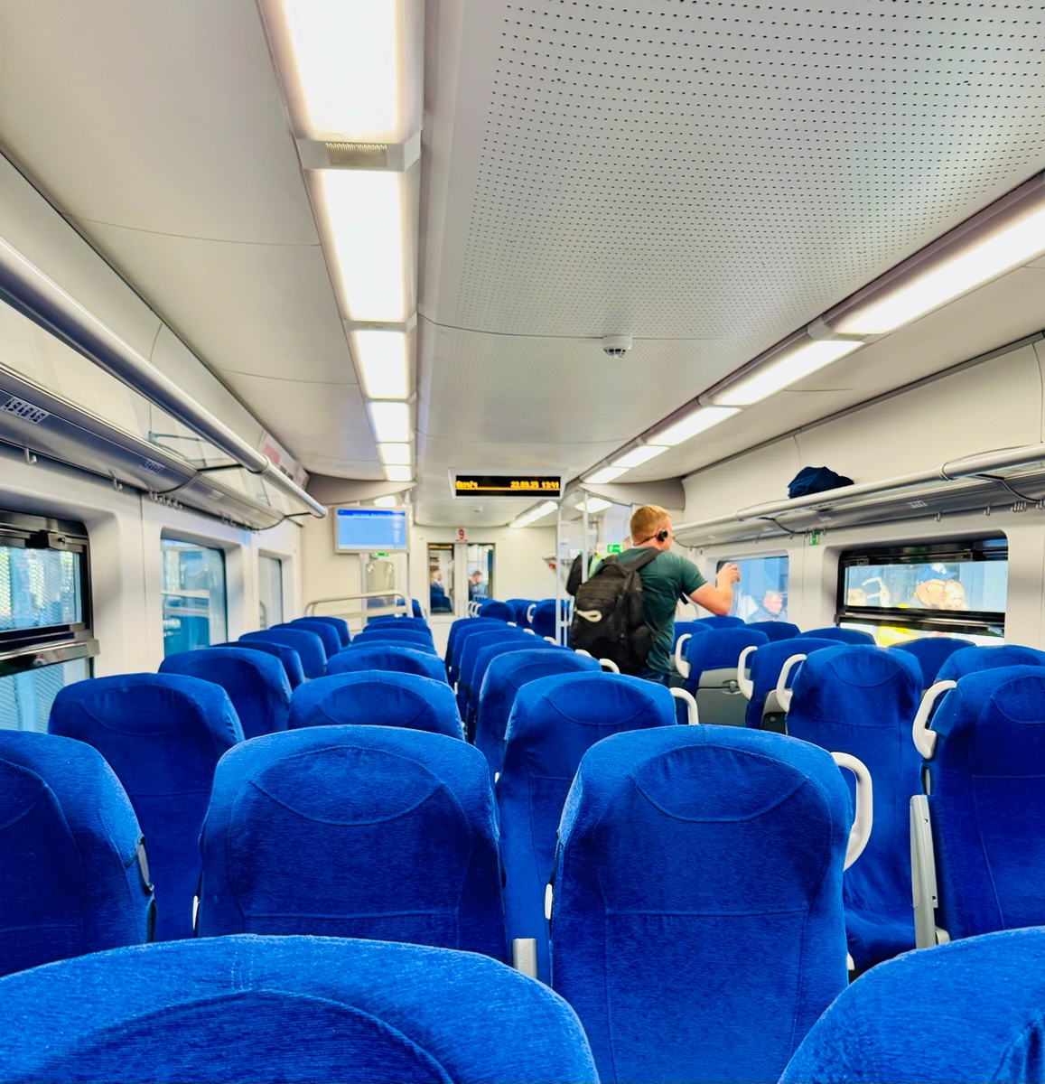 Пассажиры заходят в поезд, а проводник у входа проверяет паспорта