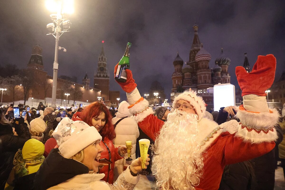   Maxim Shipenkov / EPA / TASS- Люди празднуют Новый год у Московского Кремля в Москве. Россия, 1 января 2025 года