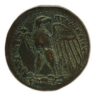 Реверс бронзовой монеты Птолемея II. Хорошо видно углубление в центре. Изображён символ Птолемеев — орёл на молнии