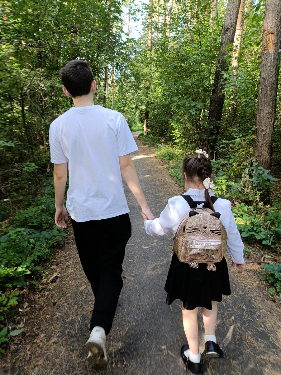 Старший брат ведёт сестру в первый класс 