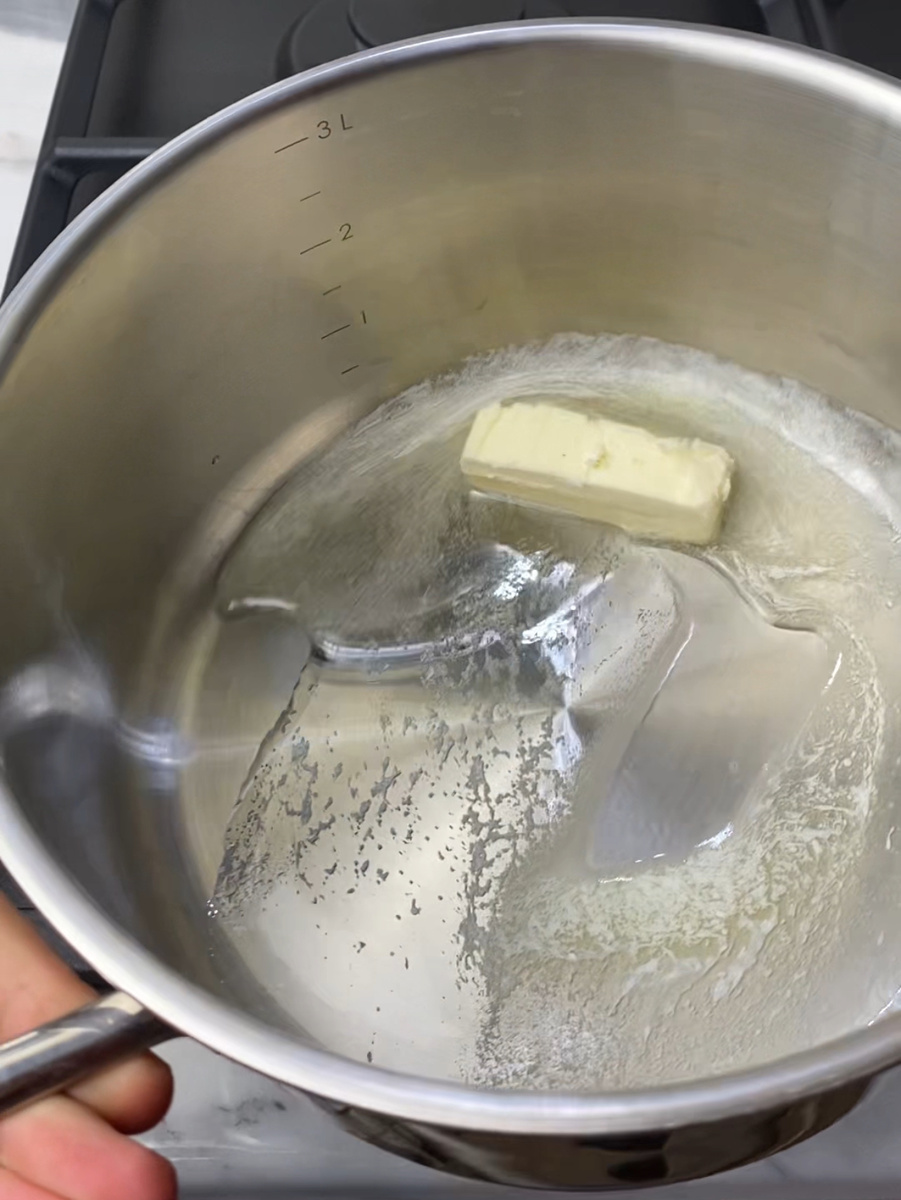 В кастрюле разогреть растительное и сливочное масло.