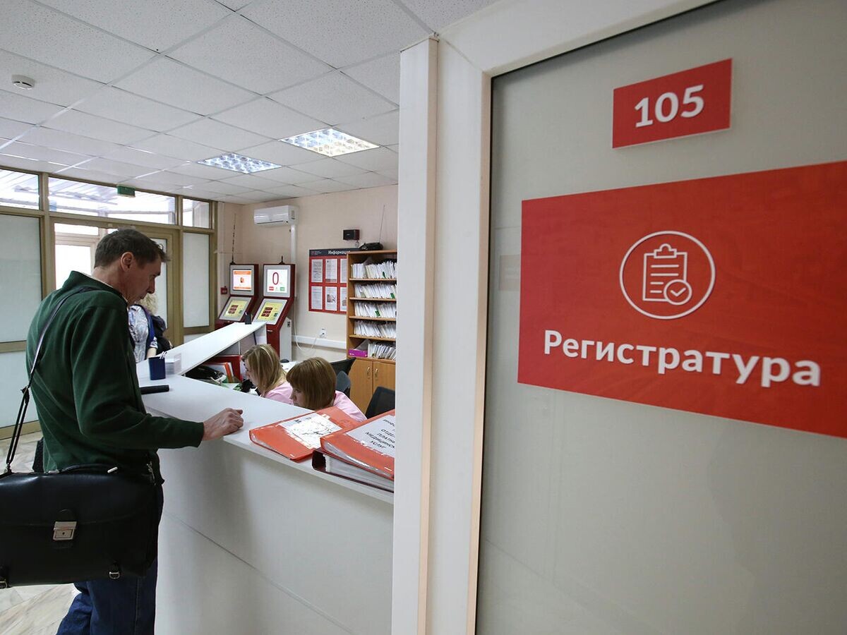    Посетитель у регистрационного стола в поликлинике© РИА Новости / Виталий Белоусов