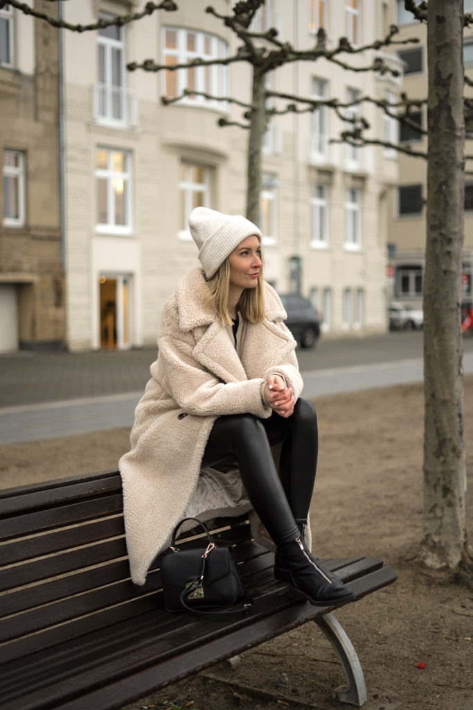 Мягкая текстура светло-бежевого пальто создает образ созерцательного отношения к переменам окружающего мира.