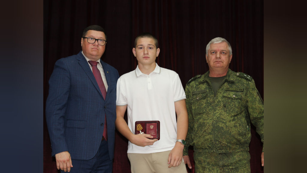    Андрей Палий и Александр Уваров вручили орден Святого Георгия - Георгиевский Крест IV степени сыну погибшего Виталия Артемьева Валерию (в центре). Фото пресс-службы райадминистрации. Евгения Орлова